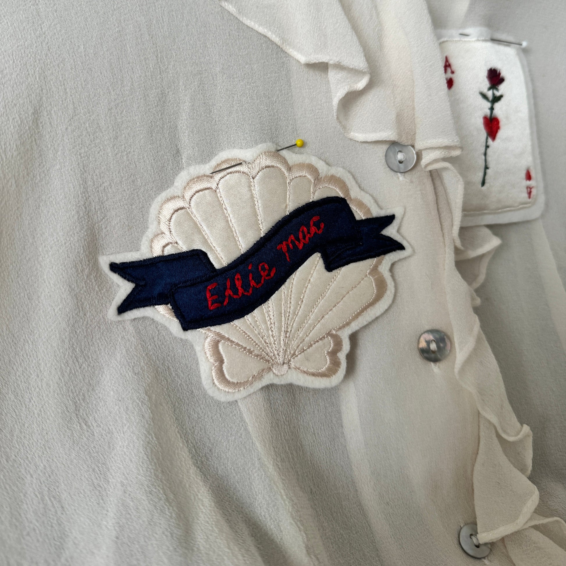 embroidered shell patch on silk blouse