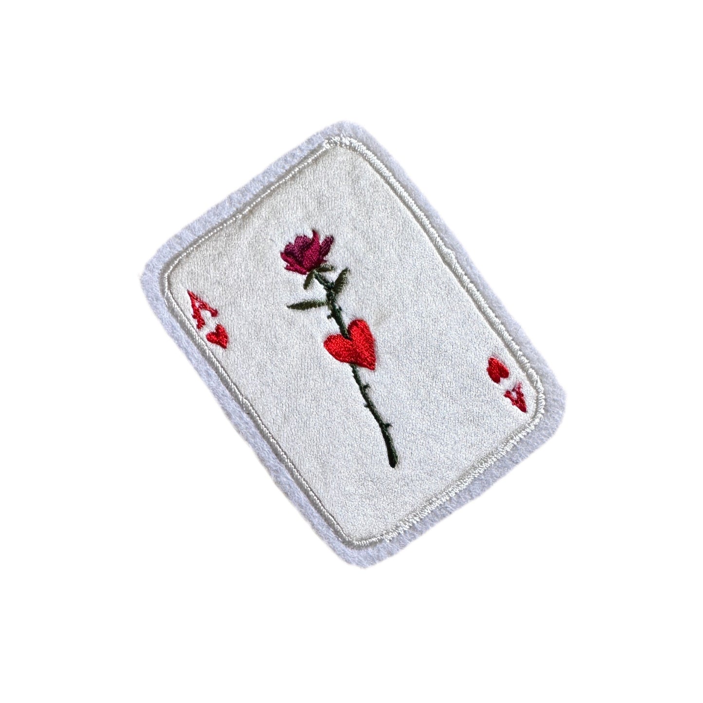 Embroidered playing card patch with a rose and hearts design on a white background