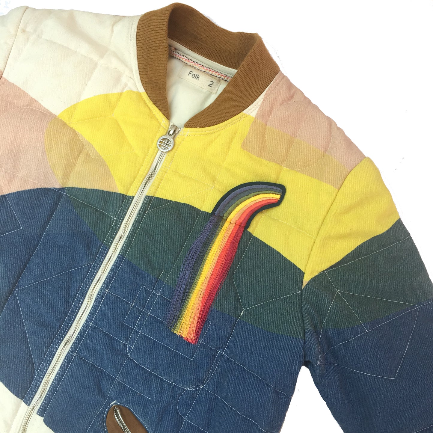 Fringed rainbow embroidered patch on quilted jacket