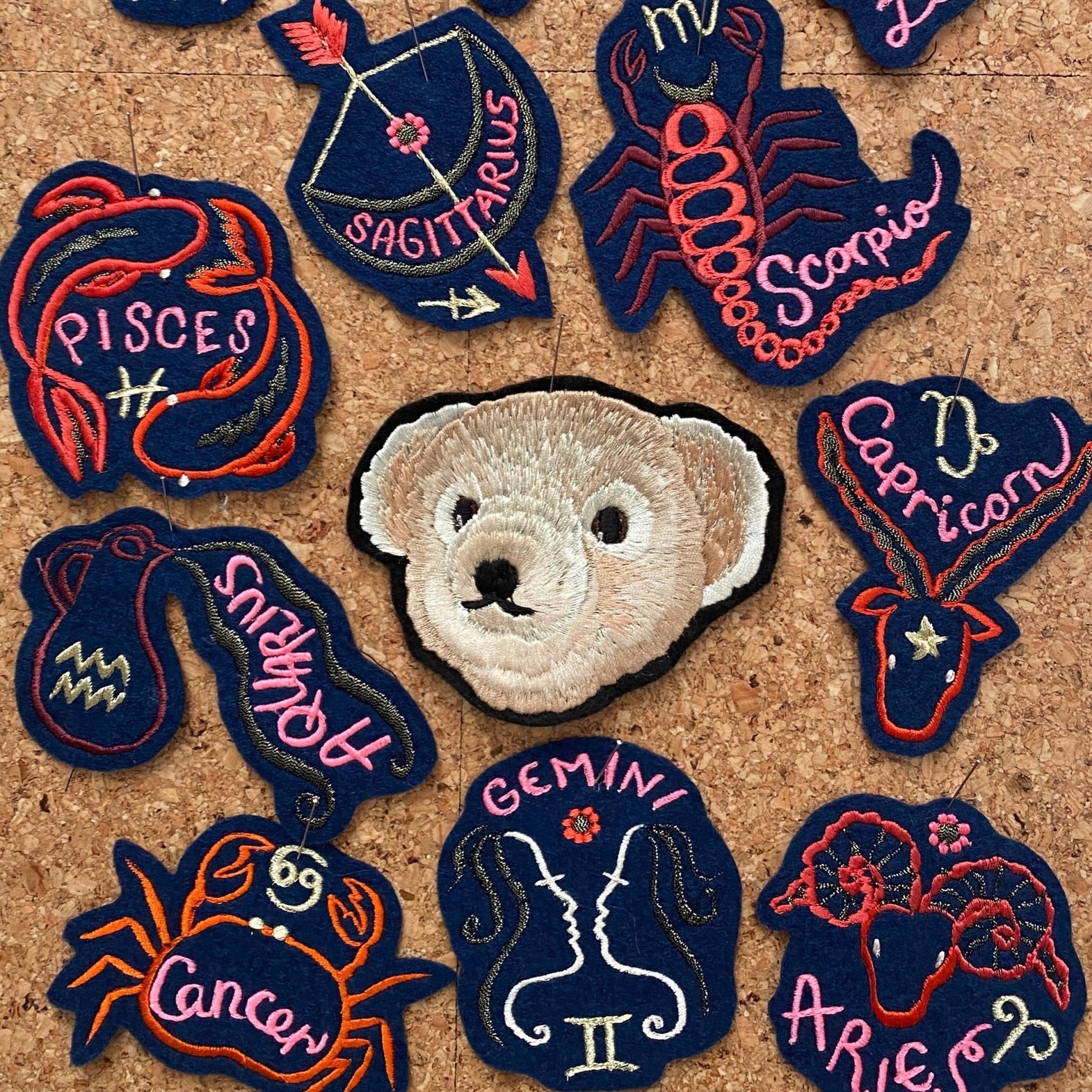 Ellie Mac embroidery's cork board with zodiac patches pinned to it