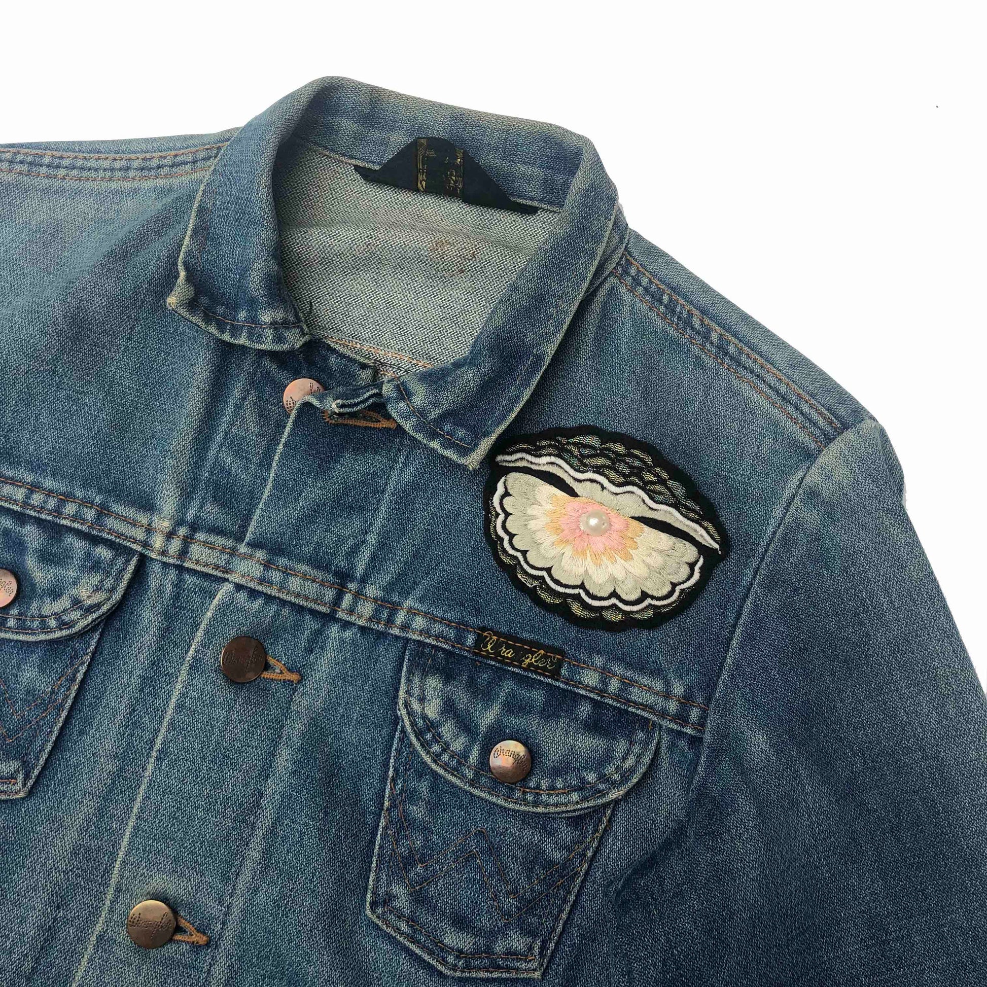 Oyster with pearl embroidered patch shown on front shoulder of a blue denim jacket