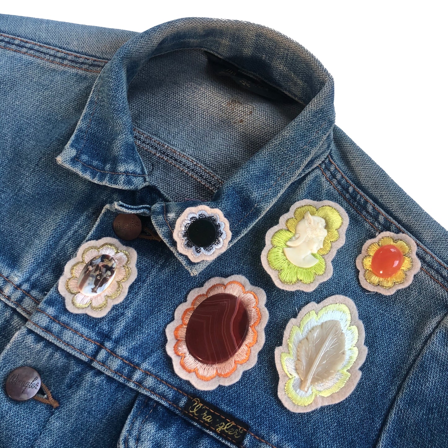 Selection of gemstone embroidered patches on front shoulder of a blue denim jacket