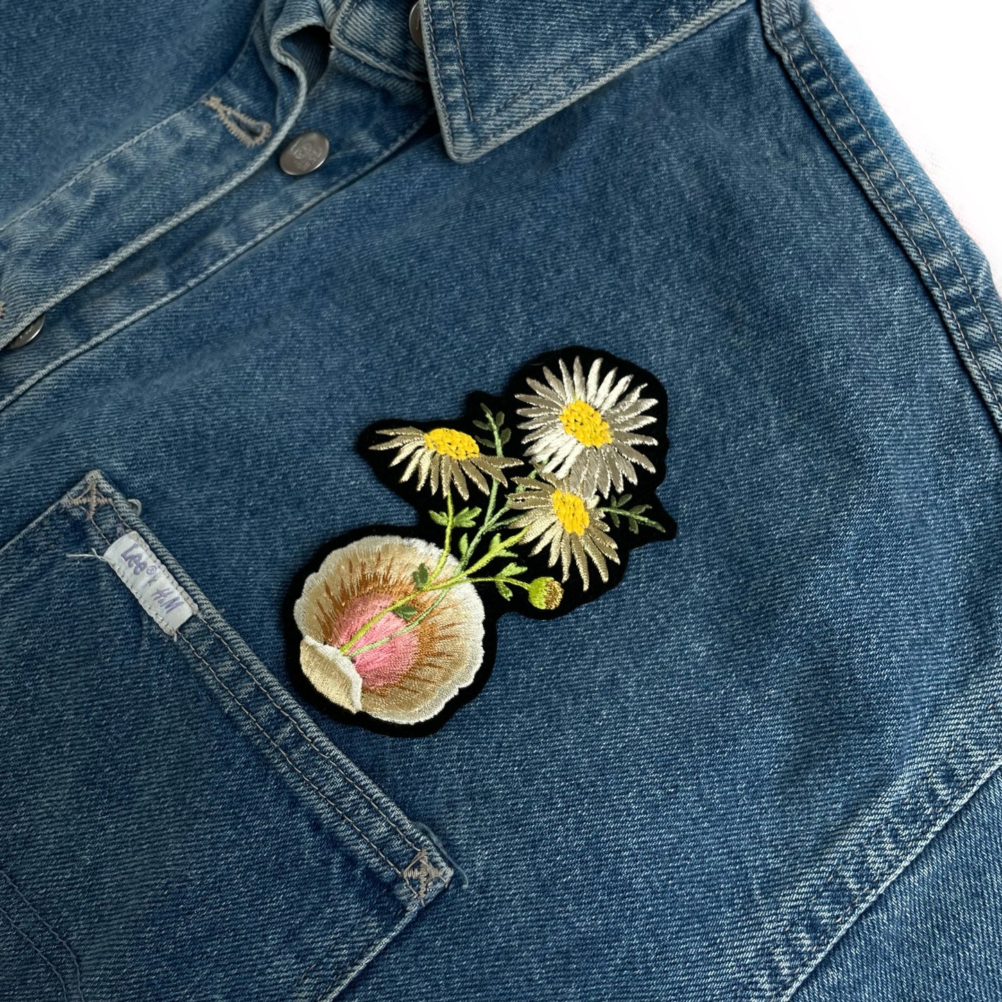 Metallic Daisy & Shell Embroidered Patch shown above pocket on a denim jacket