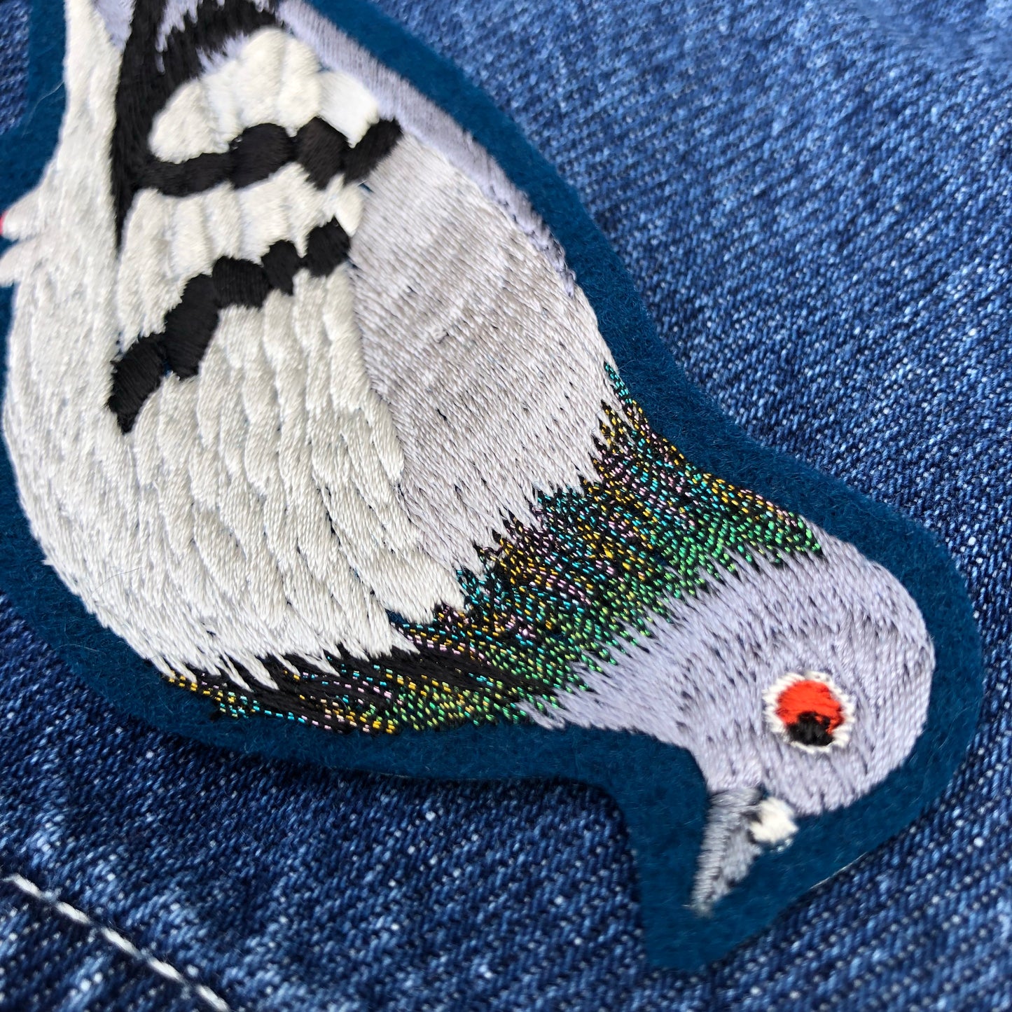 Close-up of pigeon embroidered patch showing metallic neckline of the pigeon