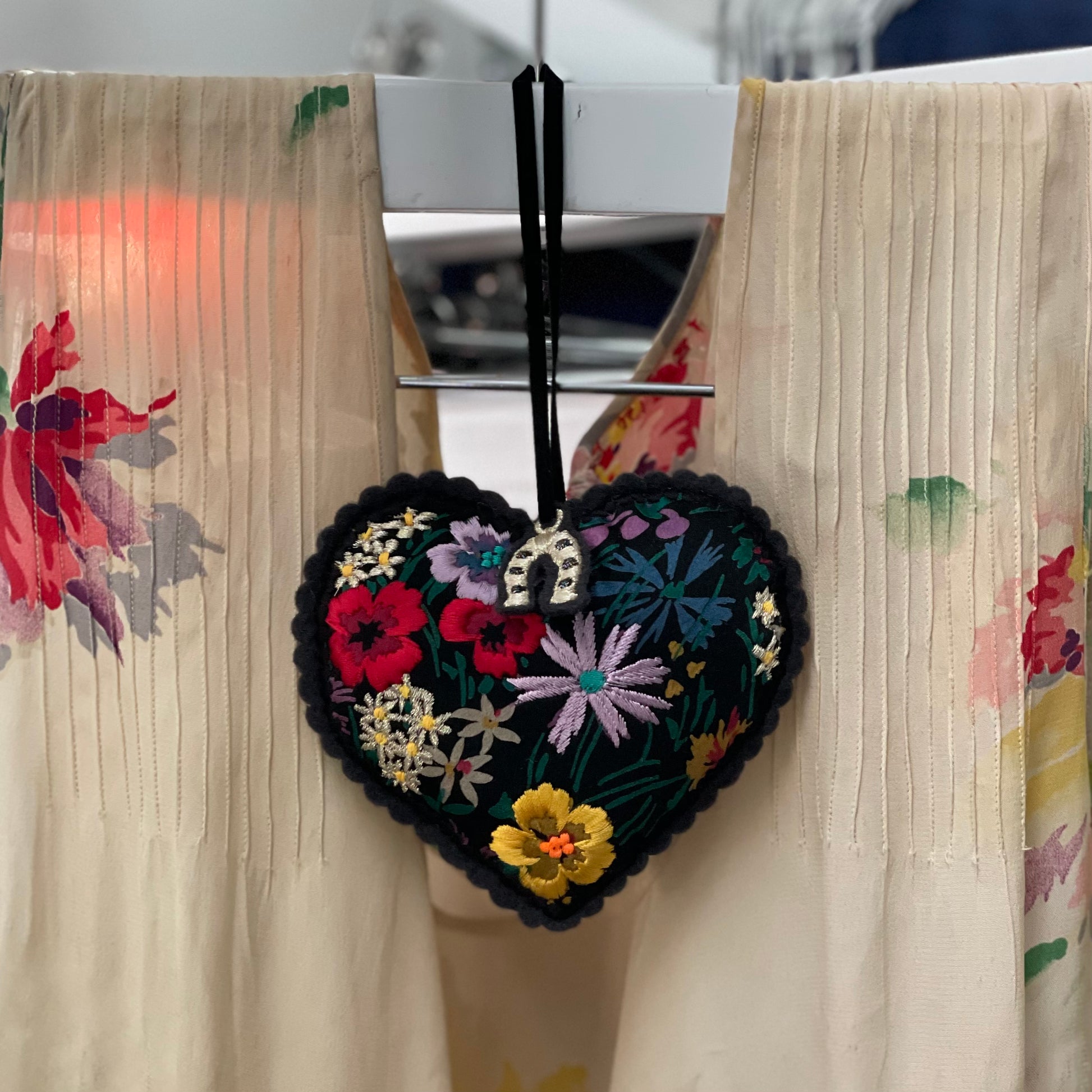 Embroidered padded hanging heart shown looped over a hanger