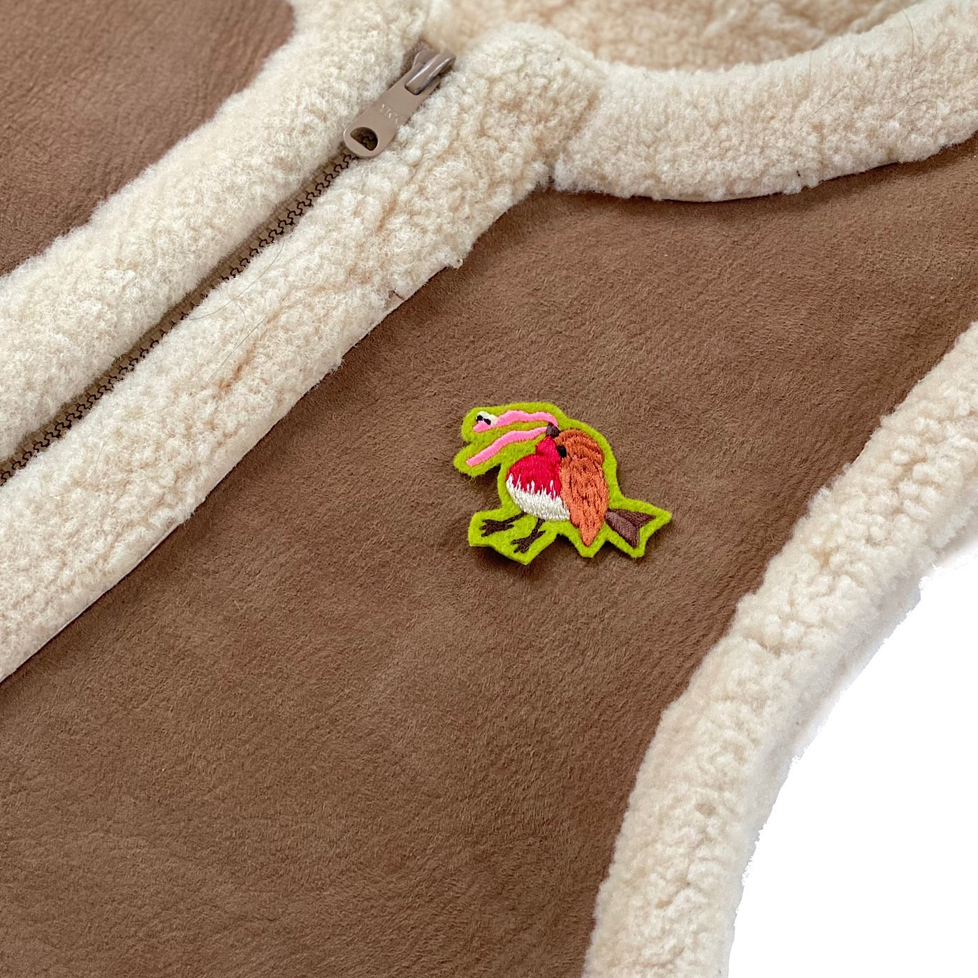 Tiny robin embroidered patch on the front of a winter gilet