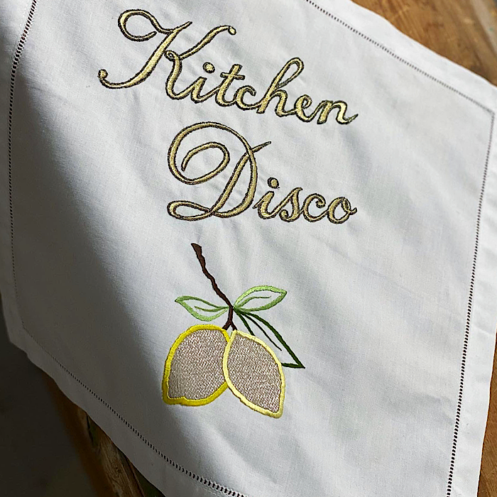 Kitchen Disco embroidered artwork hanging over edge of a table