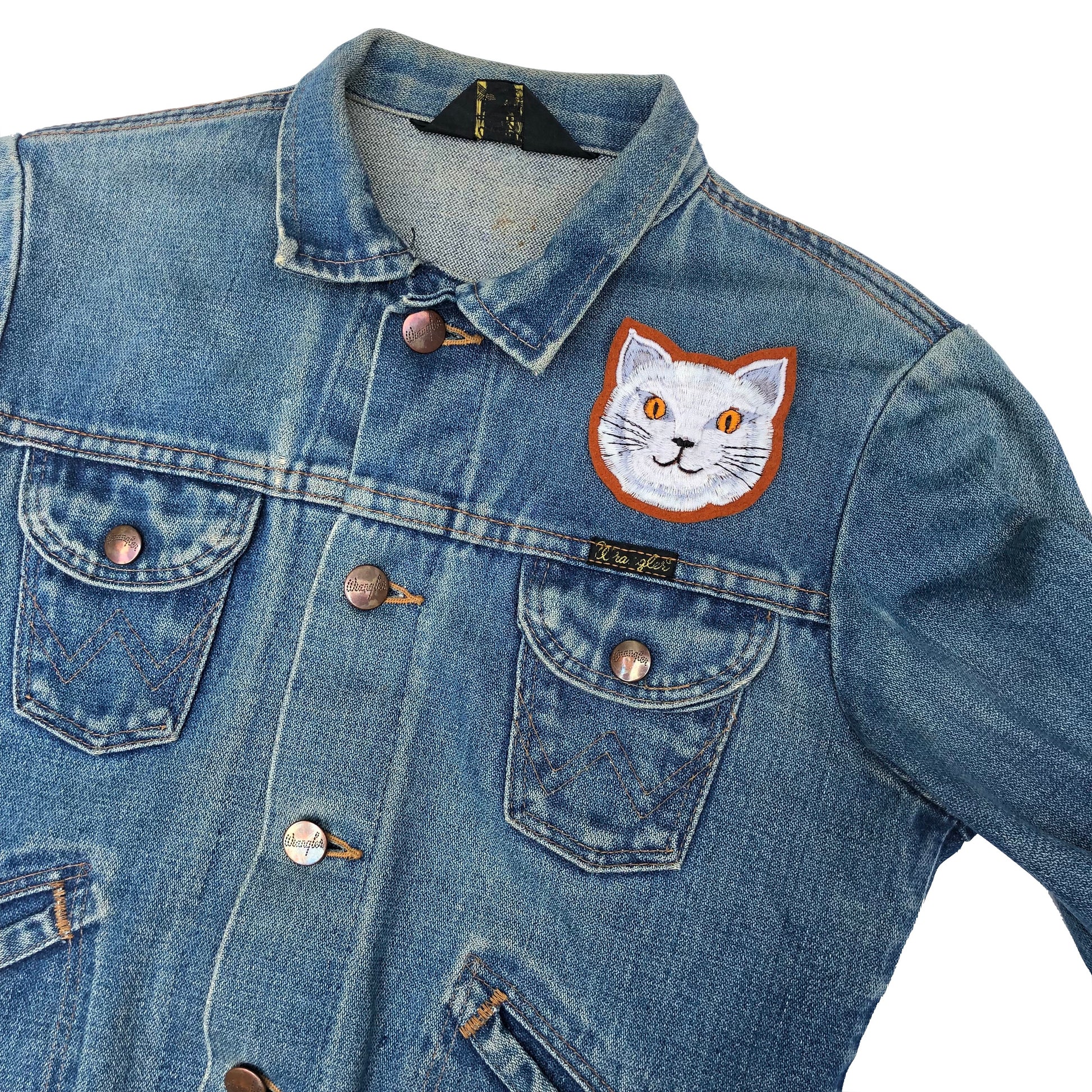 Fat cat embroidered patch on front shoulder of blue denim jacket