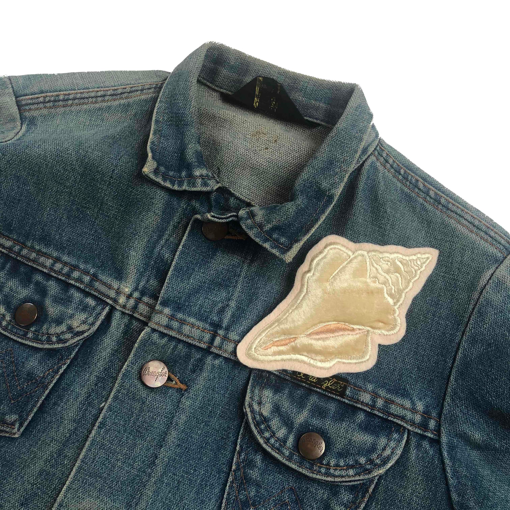 Velvet conch shell embroidered patch on front shoulder of blue denim jacket