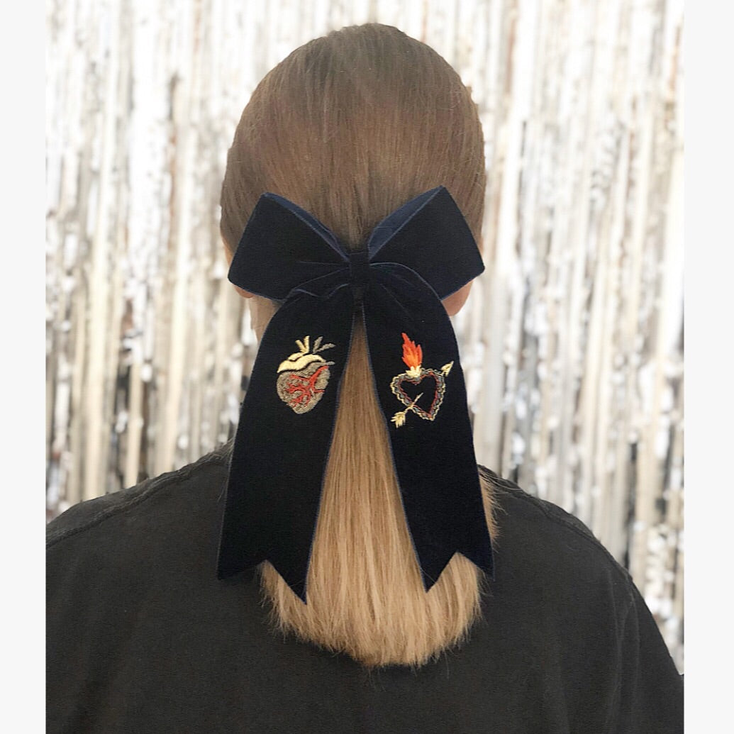 Navy velvet hair bow seen on the back of a person with long brunette hair