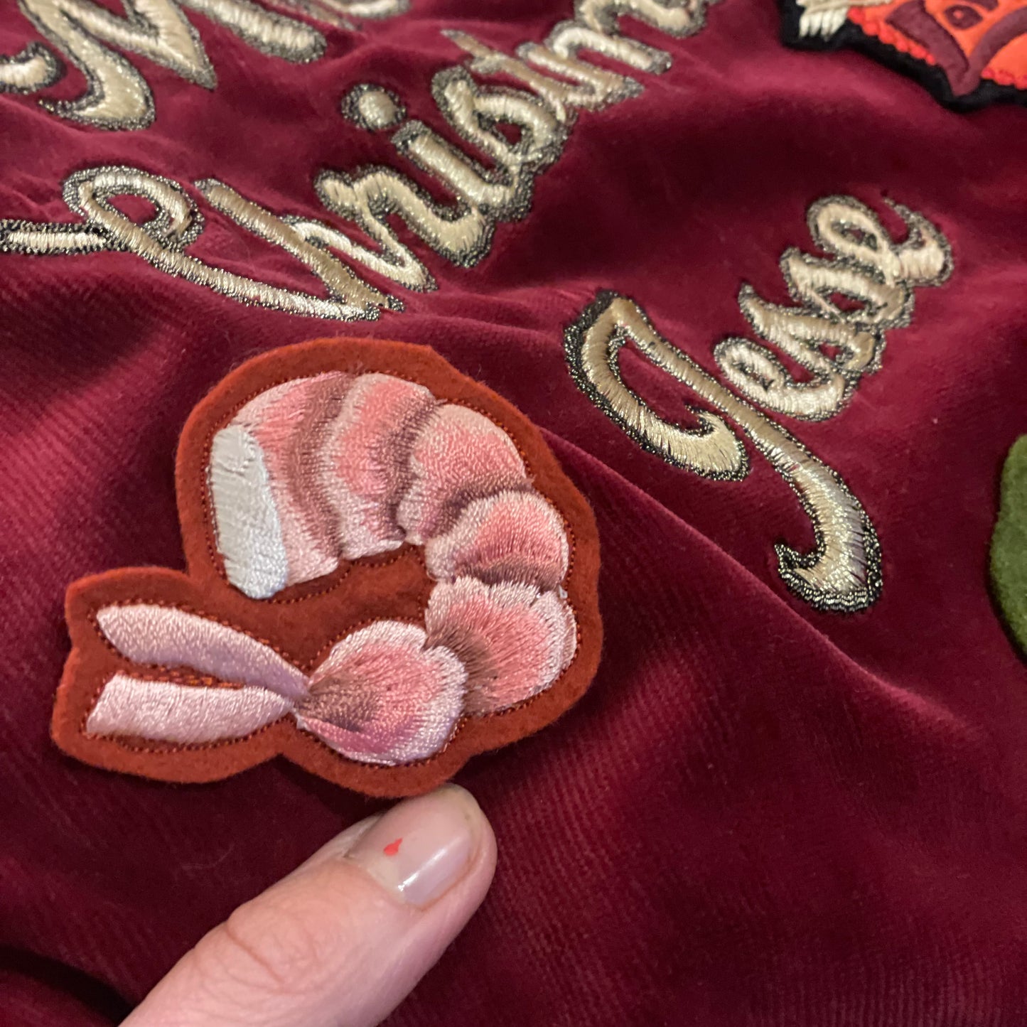 Close-up of maroon velvet Christmas sack with the prawn embroidered patch stitched on