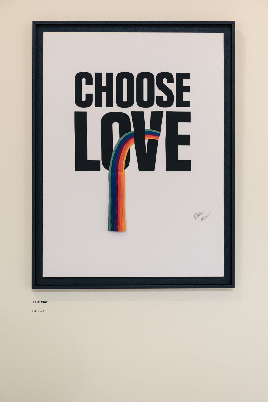 Choose Love collborative artwork with embroidered fringed rainbow. Artwork in black frame on white background.