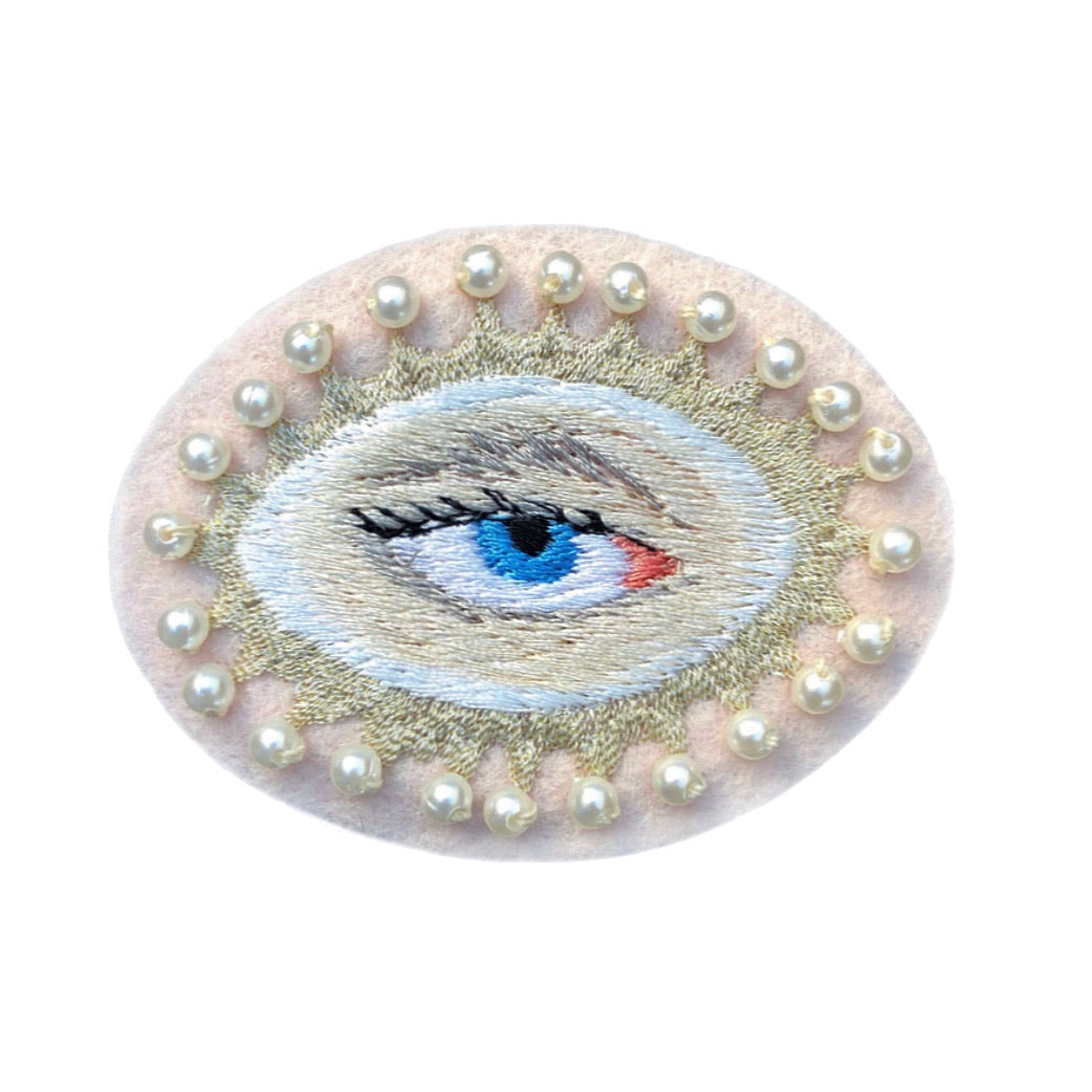 Lover's eye embroidered patch with blue iris on white background