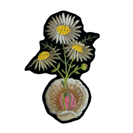 Embroidered patch of a flower and shell on white background