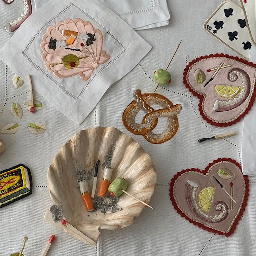 Different collaborative artworks from the Alma Berrow & Ellie Mac Embroidery collection, including embroidered artworks and napkins and ceramics