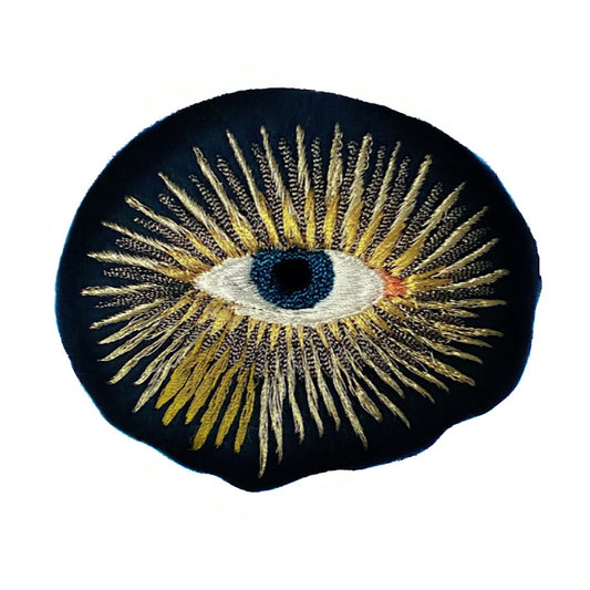 Metallic eye embroidered patch on white background