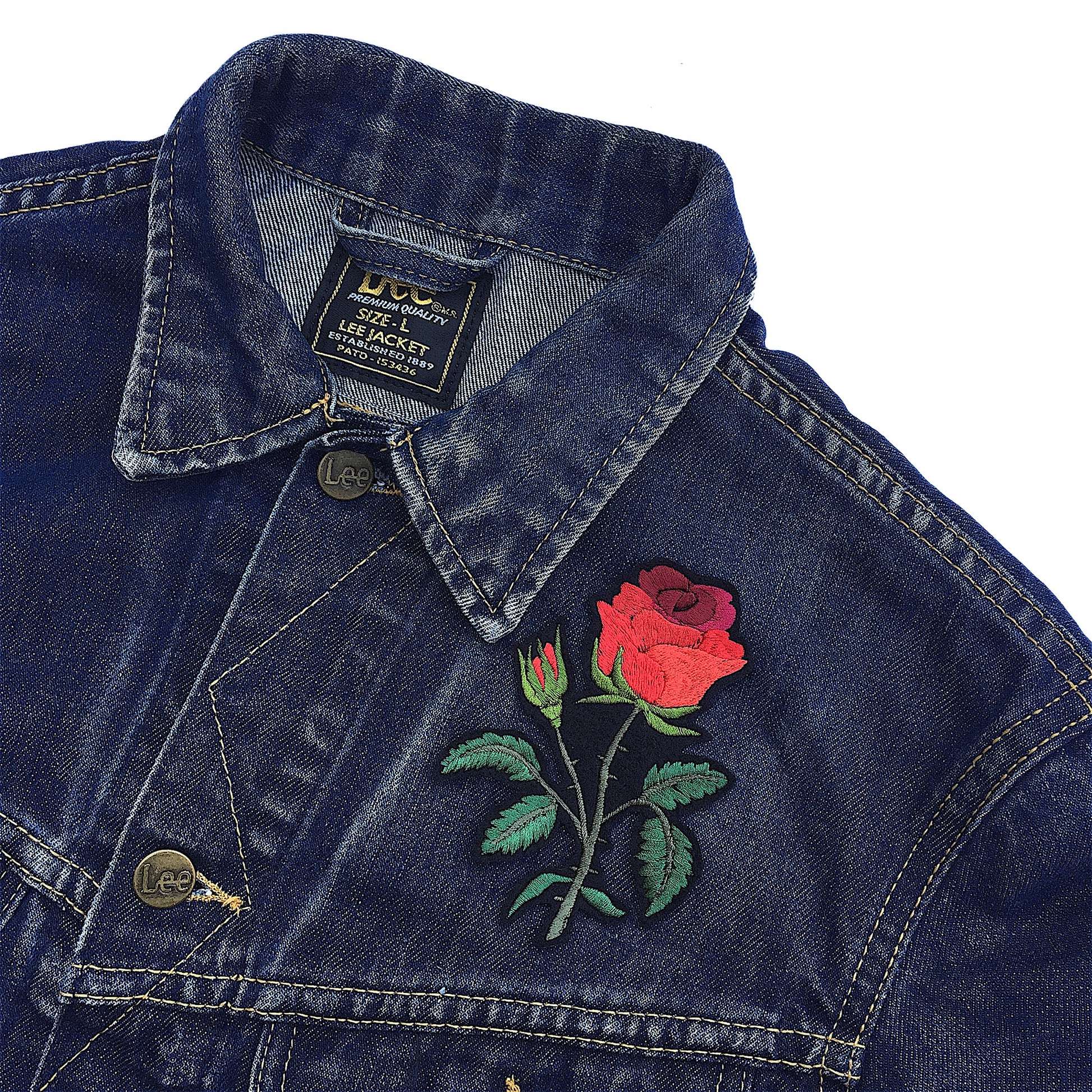 Red rose embroidered patch on the front breast of a denim jacket