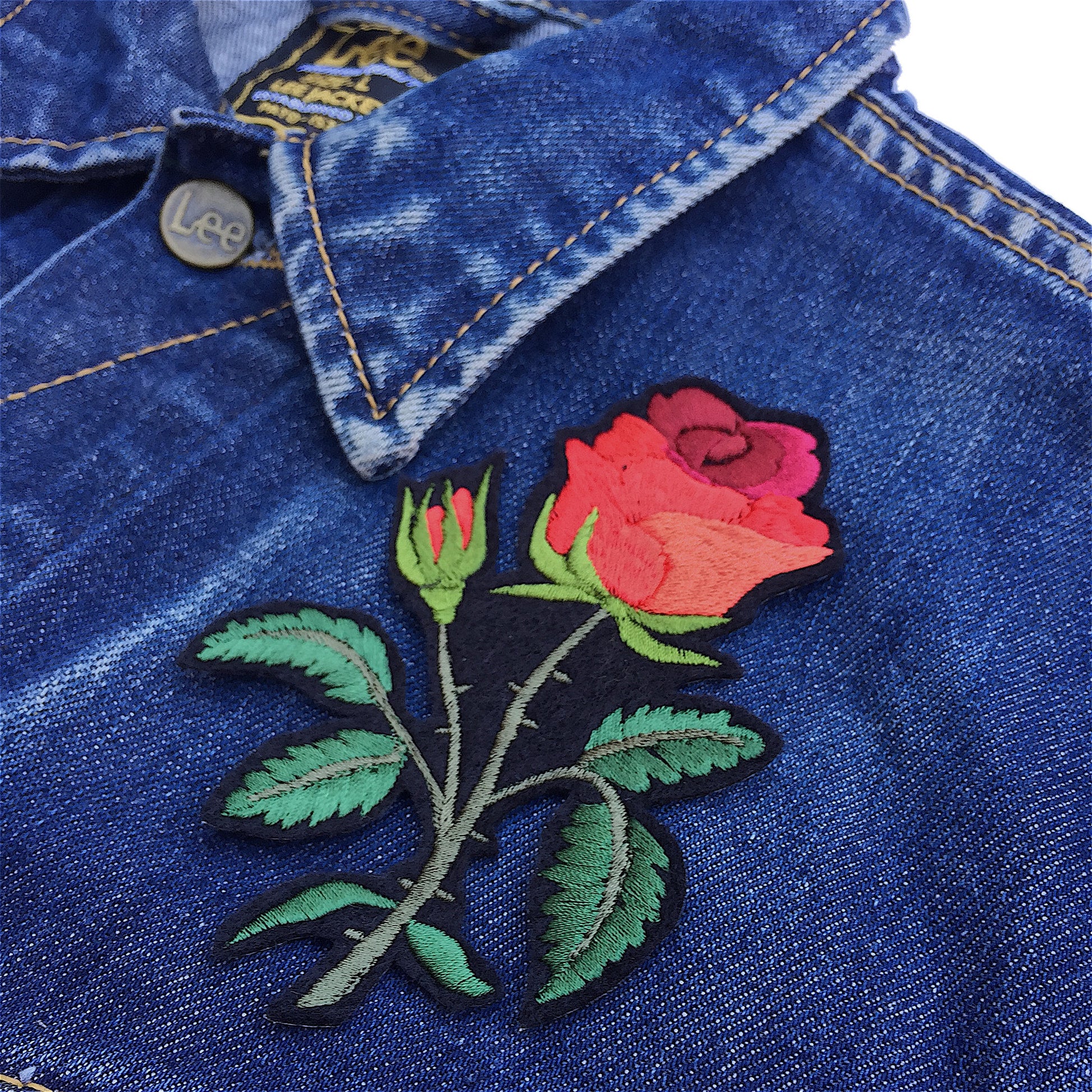 Red rose embroidered patch shown on front of a denim jacket