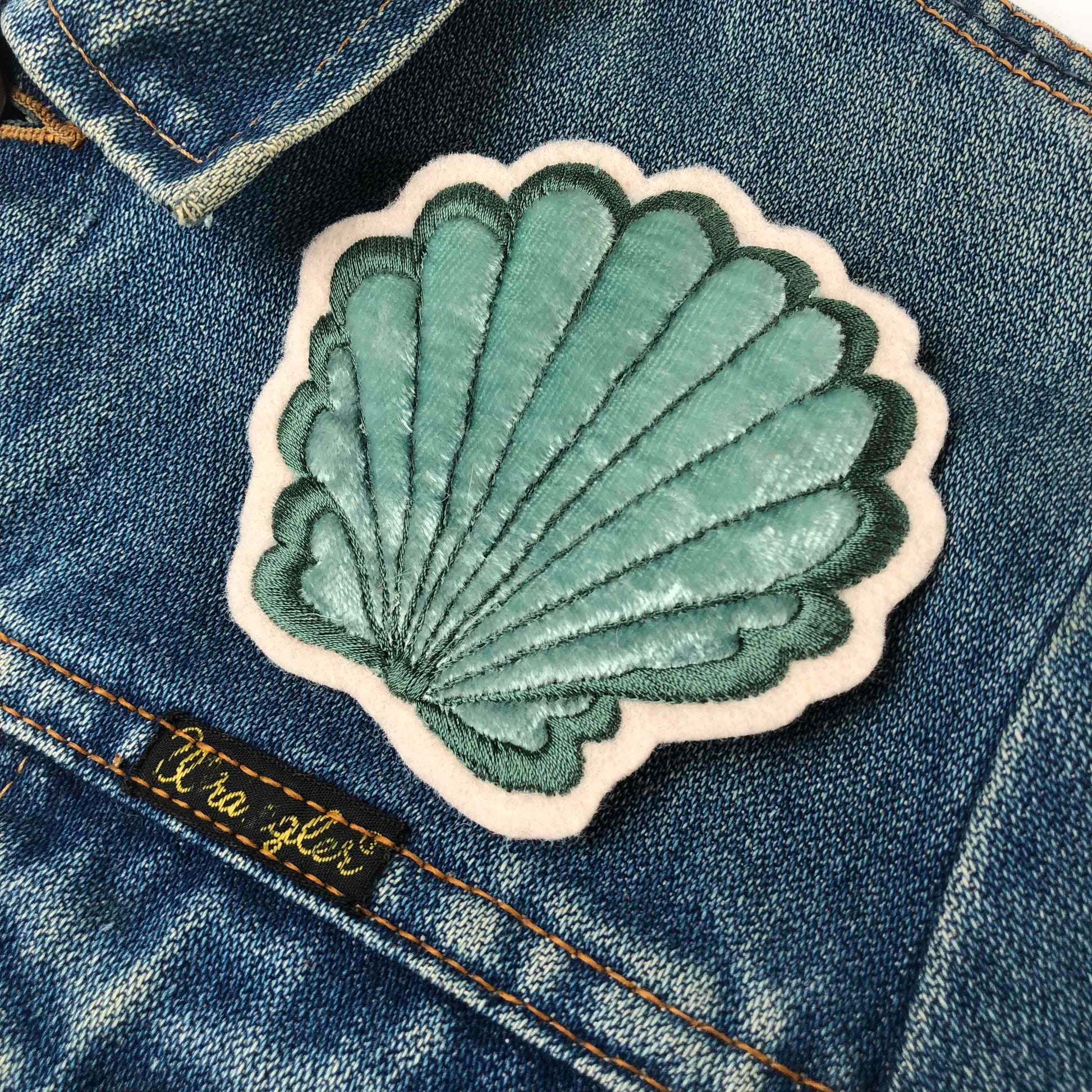 Close-up of velvet padded shell patch on the front shoulder of a dark blue denim jacket